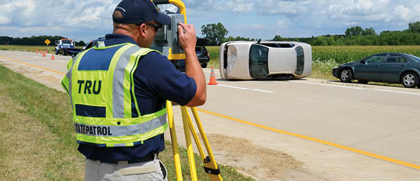 Member of the Technical Reconstruction Unit conducting a scene survey at the scene of a mock crash exercise
