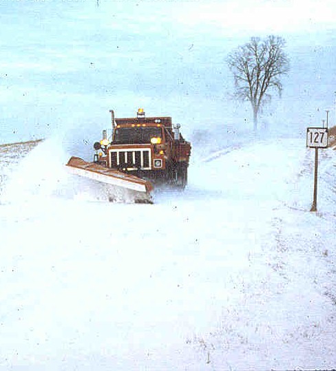Snowplow creating a path on highway 127