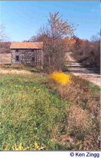 An old house basks in an autumn field beside Rustic Road 21