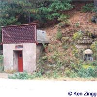The cellar door and window peek from the cliff into which they burrow